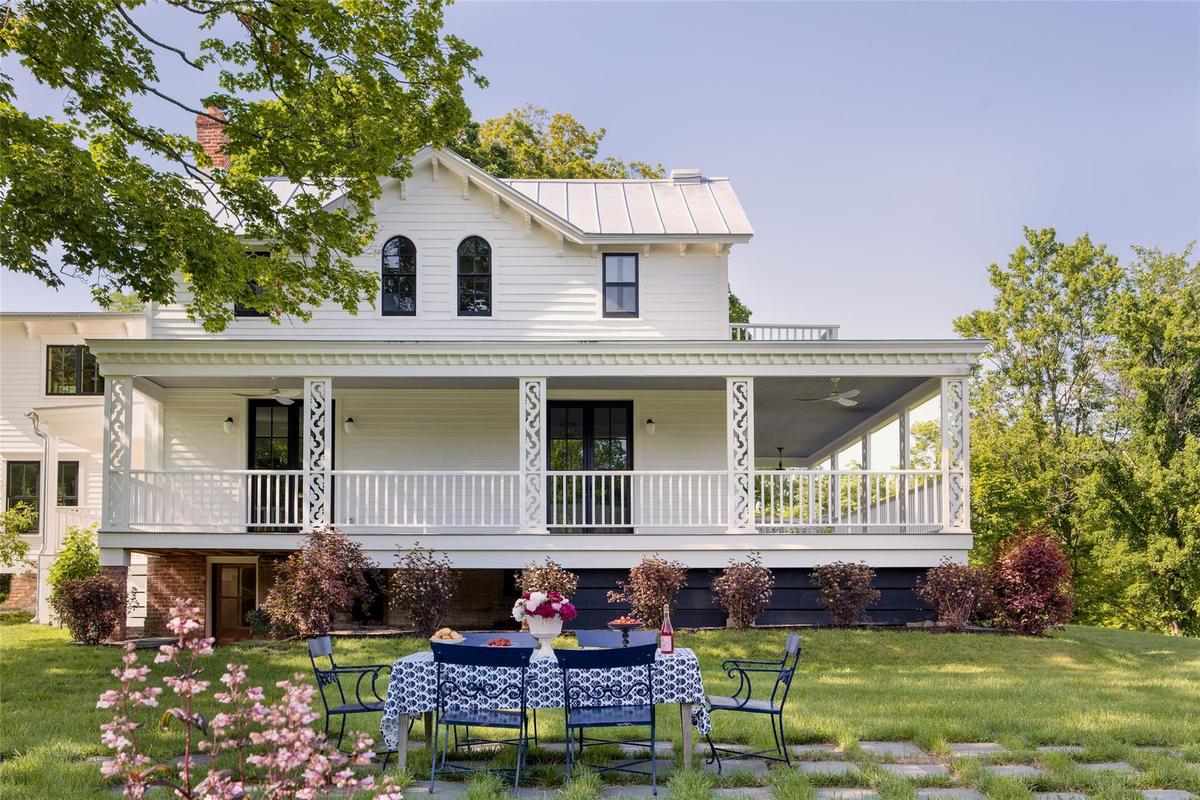 Farmhouse inspired home featuring a front yard, outdoor dining space, and a porch