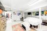 Sloped ceiling room featuring wood-finish flooring, a double window, and a flush-mount light fixture