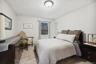Bedroom featuring light wood-style floors, ornamental molding, and a baseboard radiator