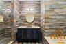 Bathroom featuring vanity, a walk in shower, and tile walls