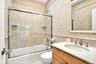 Third Oceanfront Bedroom en-suite bathroom. Full bath with tile walls, vanity, shower / bath combination with glass door, and tasteful backsplash