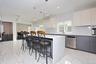 Kitchen featuring a kitchen bar, light marble finish floors, decorative light fixtures, white cabinets, and recessed lighting