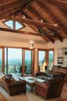 Living area with vaulted ceiling with beams, wooden ceiling, and a water view