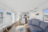 Living room featuring dark wood-style floors, recessed lighting, and a wall mounted air conditioner