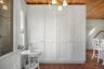 Floor-to-ceiling white beadboard cabinetry with nickel hardware, wood-finish ceiling, and terra cotta tile flooring