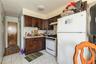 1st floor Kitchen with white appliances, light countertops, tasteful backsplash, dark brown cabinets, and under cabinet range hood