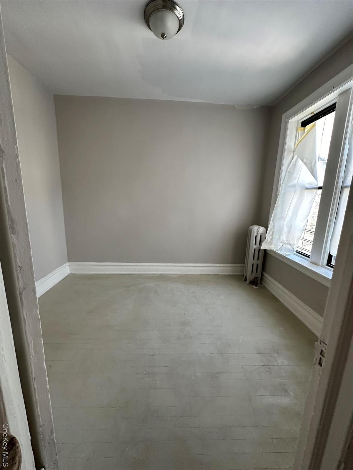 Empty room with radiator and baseboards