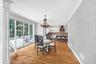 Hardwood flooring, crown molding, wall paneling, French doors, and a decorative chandelier and access to outdoor patio