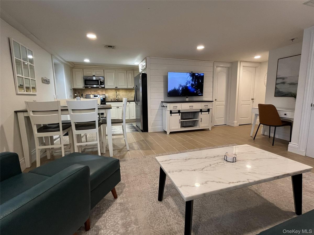 Living area with wood finish floors and recessed lighting