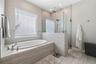 The primary bathroom offers an oversized walk-in shower and a separate soaking tub to relax in.