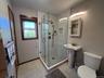 Bathroom featuring a shower stall and light tile patterned floors