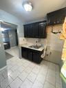 Kitchen featuring dark cabinetry, light countertops, and backsplash