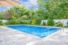 View of pool with a fenced backyard, a patio area, and view of wooded area