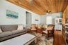 Vaulted wood-paneled ceiling with ceiling fan, light blue walls, and wood-finish flooring throughout