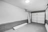 Garage interior featuring a white paneled door, gray concrete flooring, and a flush-mount ceiling light