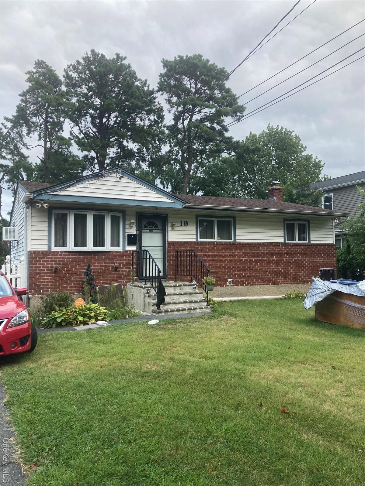 Single story home featuring brick siding, a front lawn, and a chimney
