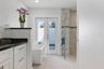 Primary ensuite bath with soaking tub, walk in shower and doors to the outdoor shower