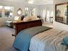 Bedroom featuring carpet, multiple windows, and ceiling fan