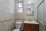Bathroom featuring vanity, a shower stall, and tile walls