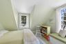 Bedroom featuring multiple windows and vaulted ceiling