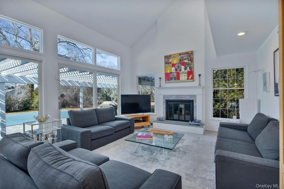Living area with a fireplace, cathedral ceilings and recessed lighting