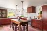 Kitchen with high end stainless steel range, custom range hood, light countertops, dark wood-style floors, and tasteful backsplash