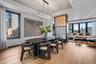 Dining room featuring light wood finished floors, a tray ceiling, a view of city, and a healthy amount of sunlight
