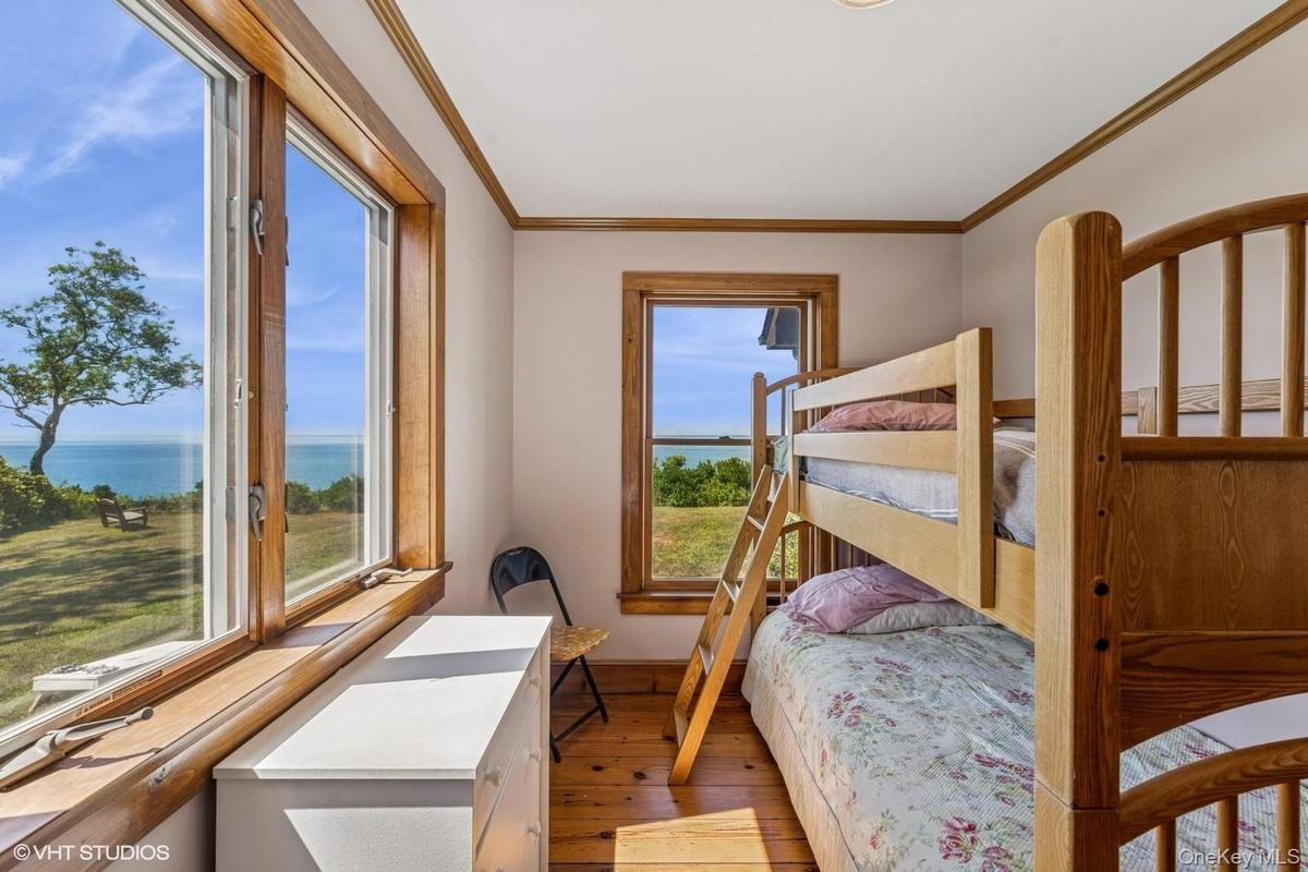 Bedroom with ornamental molding, dark wood-style flooring, and a water view
