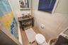 Bathroom with a shower with shower curtain, tile walls, tile patterned floors, and wainscoting