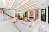 Grand open living space with soaring ceilings, breathtaking water views, a statement fireplace, and custom wine storage.