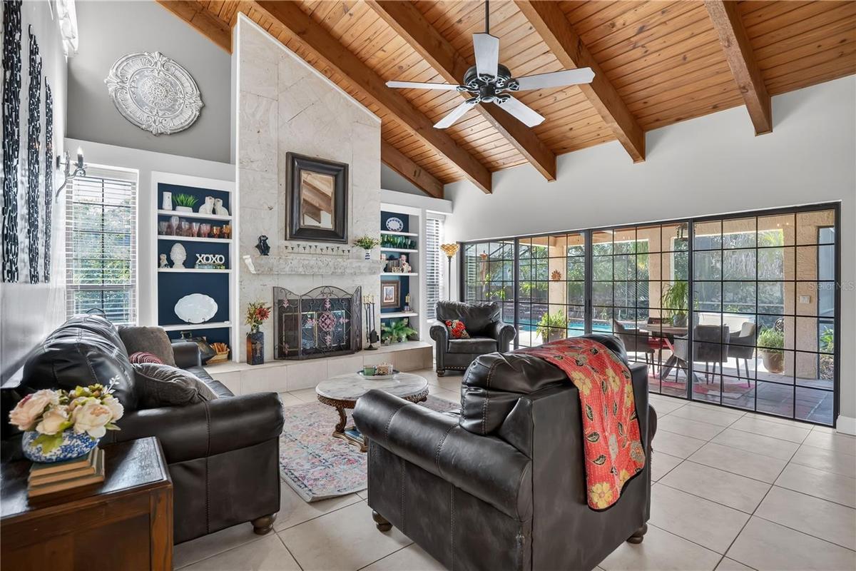 The great room with exposed wood beams and wood-burning fireplace