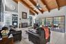 The great room with exposed wood beams and wood-burning fireplace