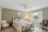 Bedroom featuring crown molding, carpet flooring, a baseboard radiator, a ceiling fan, and cooling unit