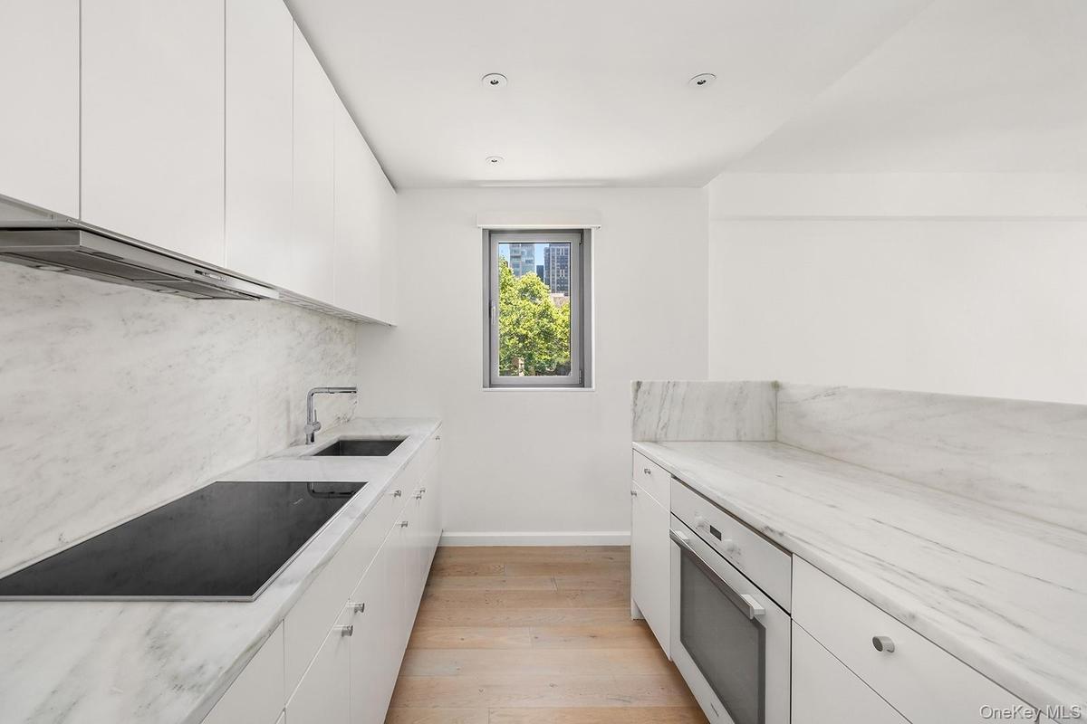 Contemporary kitchen featuring light wood-finish flooring and recessed lighting