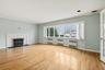 Unfurnished living room with light wood finished floors, a brick fireplace, radiator, and ornamental molding