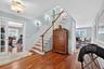 Stairway featuring wainscoting, a decorative wall, and wood-type flooring