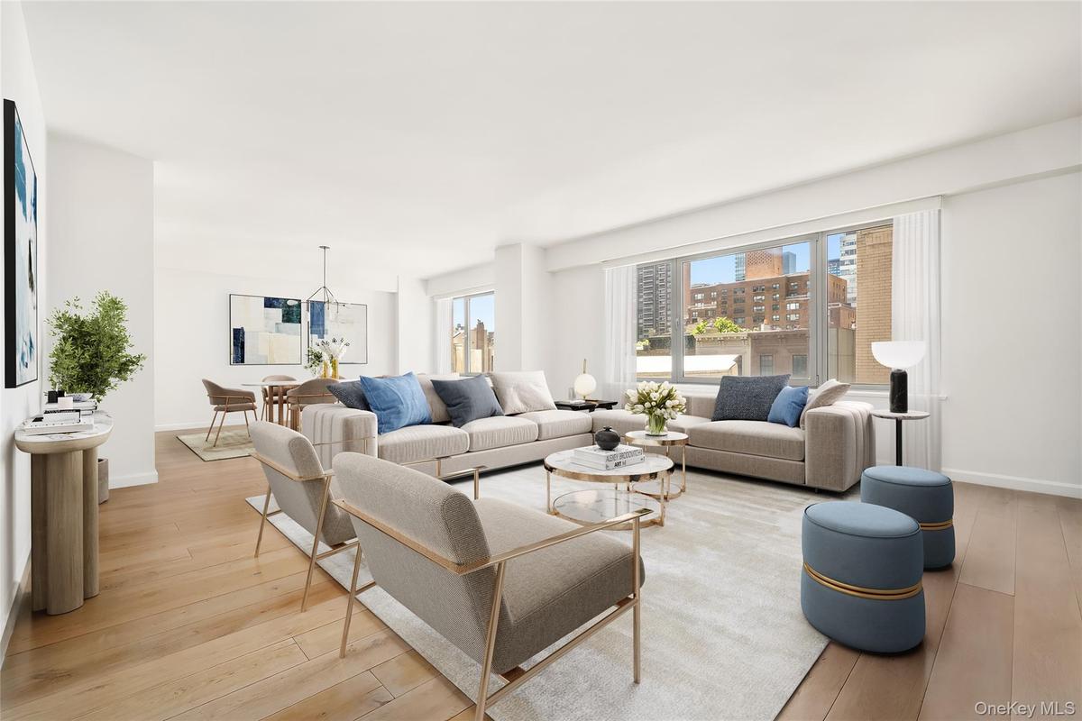 Spacious living area featuring light wood-finish flooring, recessed lighting, and a large window