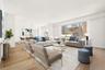 Spacious living area featuring light wood-finish flooring, recessed lighting, and a large window