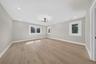Spacious room with light wood-finish flooring, recessed lighting, and a modern ceiling fixture
