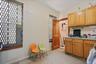 Kitchen area with wood-finish cabinetry, a stainless steel sink, and light-toned wall paint