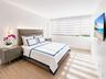 SPACIOUS BEDROOM SUITE OFFERS SITTING AREA AND TWO WALK-IN CLOSETS