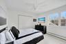 Bedroom featuring baseboard heating, wood finished floors, a closet, and ceiling fan