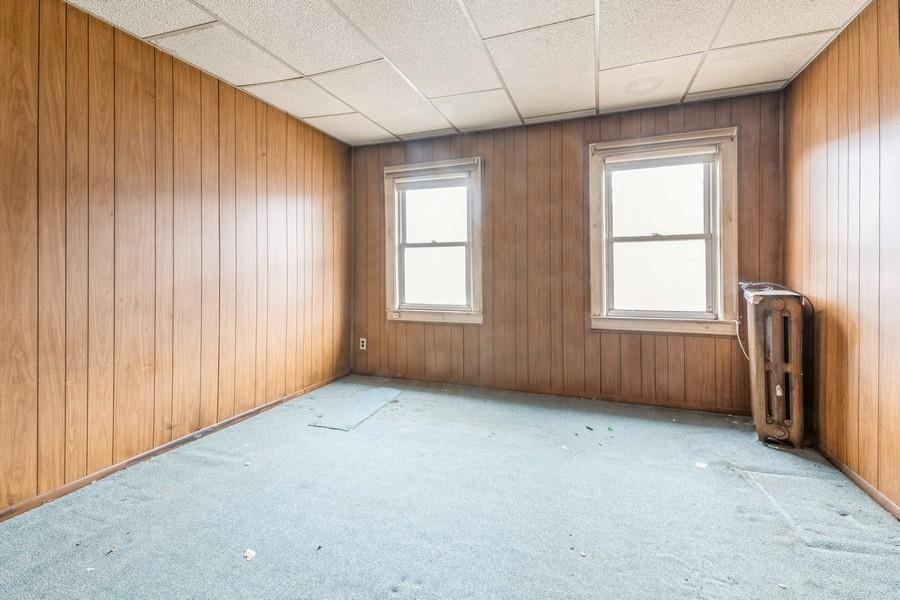 Spare room featuring radiator, a healthy amount of sunlight, and wooden walls