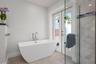 Primary bathroom with soaking tub and doors to the outdoor shower