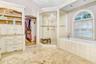 Large walk in steam shower with custom tile and shampoo nooks. Doorway to master bedroom closet.