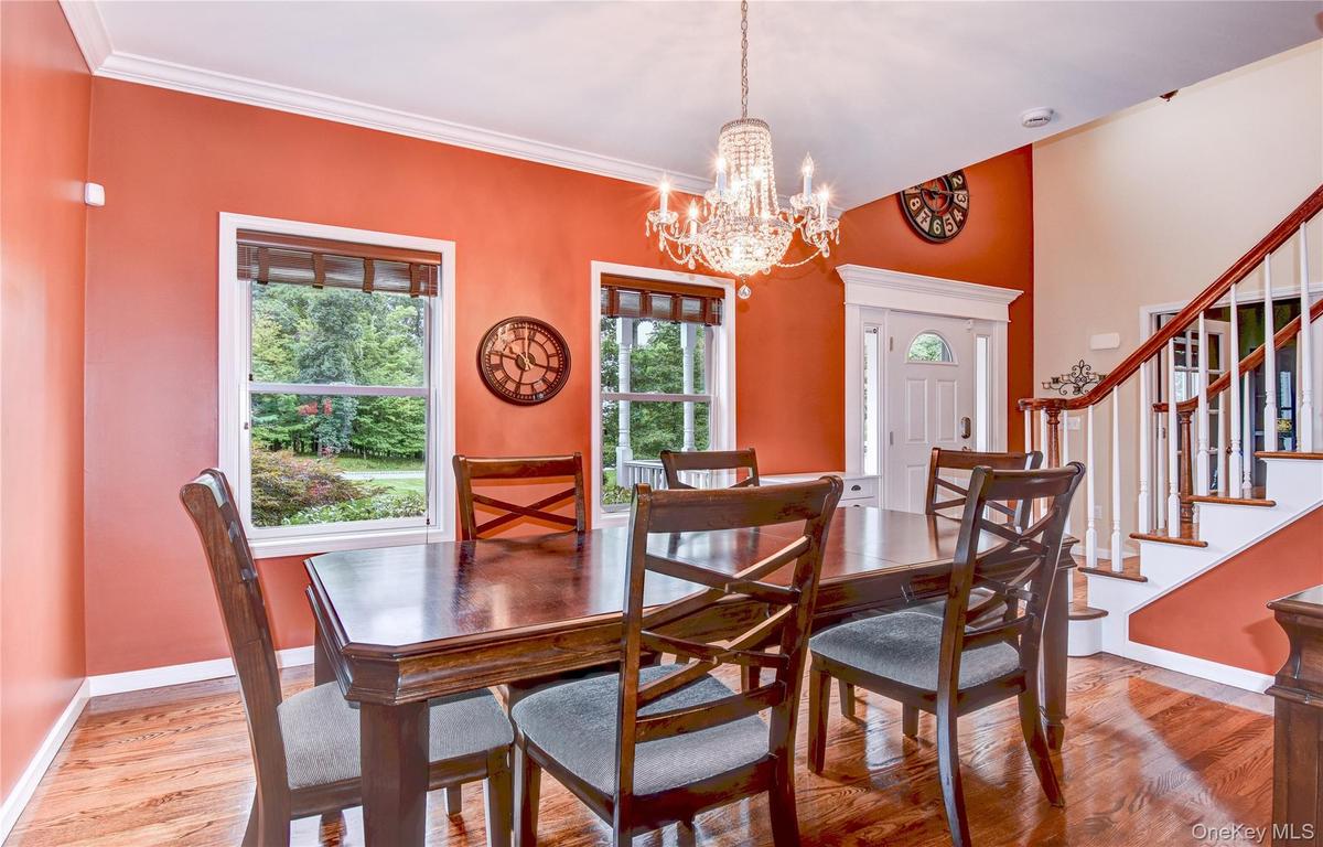 Dining space featuring wood  flooring, a crystal chandelier, and two large windows