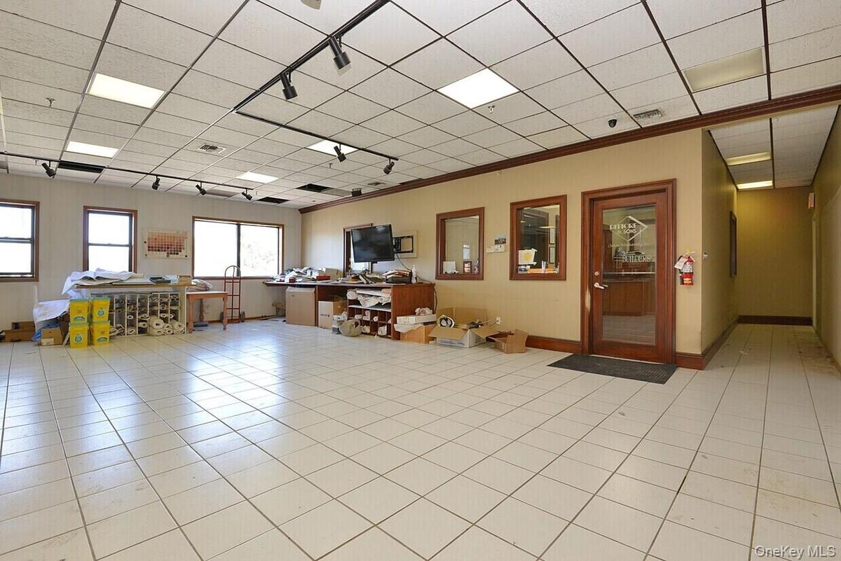 Office space featuring a drop ceiling, ornamental molding, light tile patterned flooring, and baseboards
