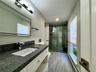 Full bath featuring a baseboard heating unit, vanity, and a stall shower