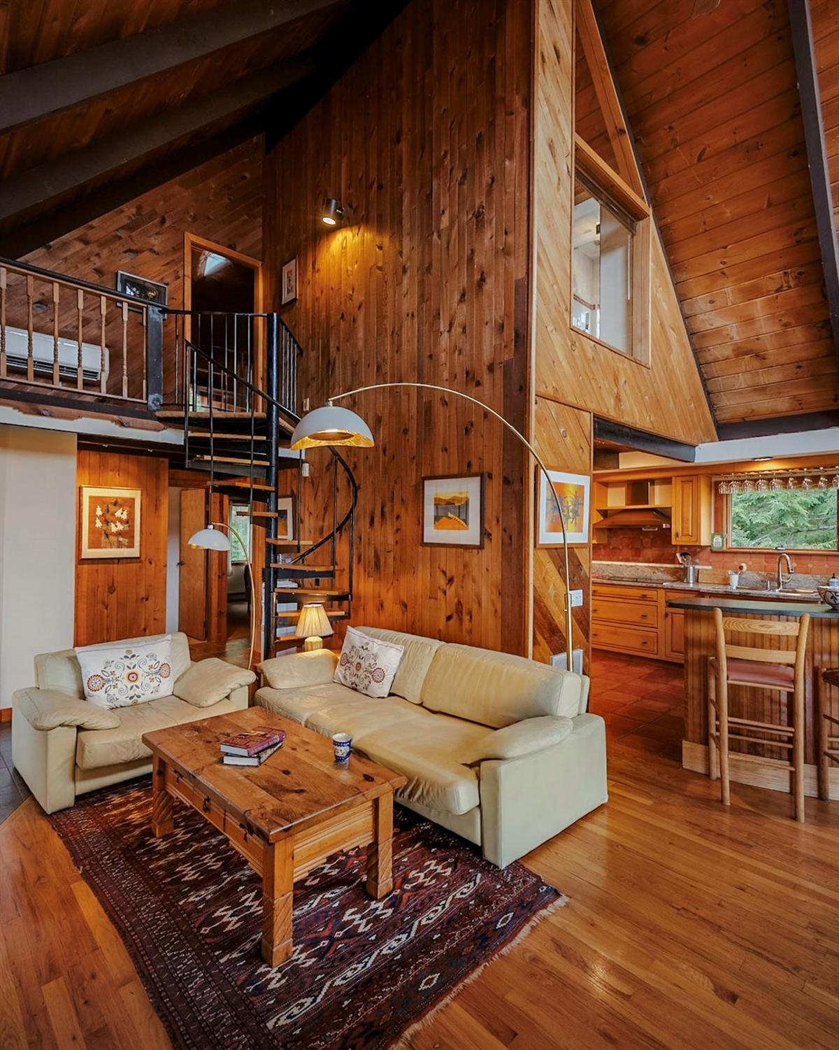 Living room featuring wooden ceiling, stairway, wood finished floors, wood walls, and high vaulted ceiling