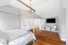 Hardwood flooring, vaulted ceiling, crown molding, white paneled doors, and a gold-tone chandelier